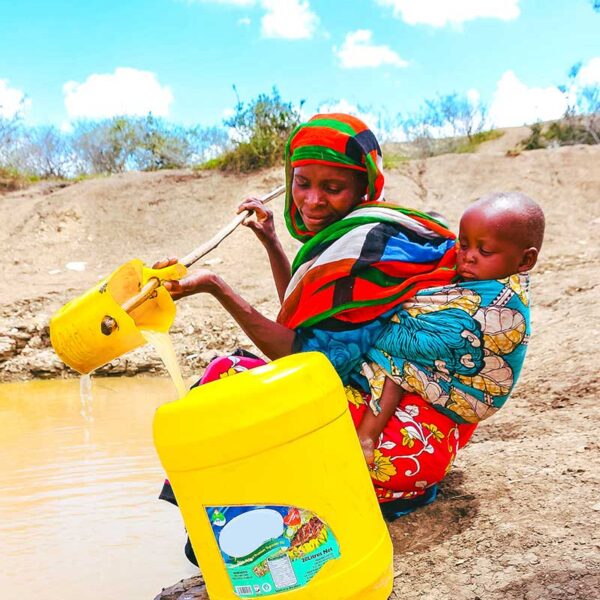 Lady collecting dirty water. The Stream Project